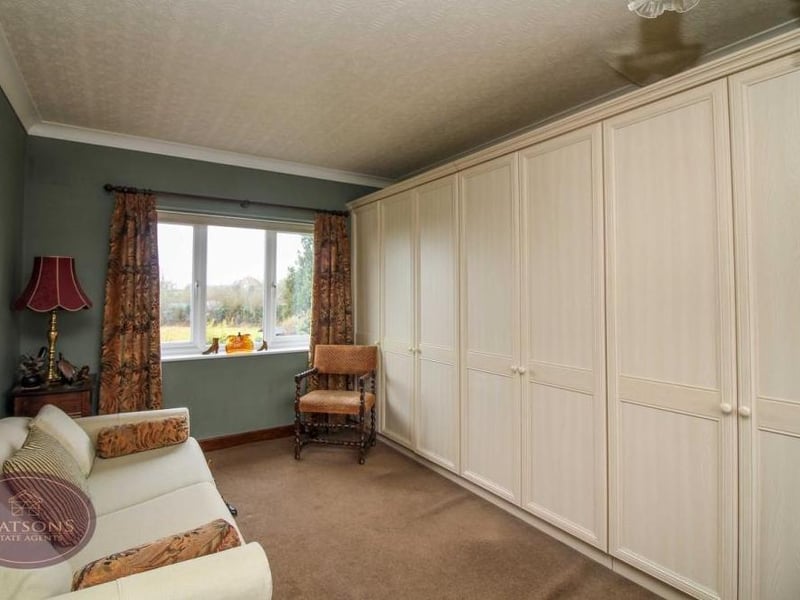 The second bedroom features wall-to-wall, fitted wardrobes. There are windows to the front and back of the house.