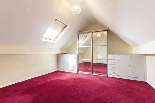 Moving on to the first floor now and we come across another sizeable bedroom. It boasts a range of fitted furniture, including wardrobes, drawers and base units. Natural light flows through a wooden-framed Velux window.