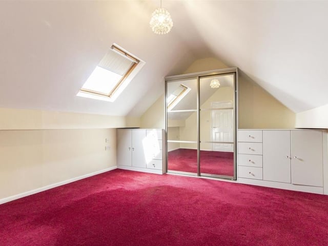 Moving on to the first floor now and we come across another sizeable bedroom. It boasts a range of fitted furniture, including wardrobes, drawers and base units. Natural light flows through a wooden-framed Velux window.