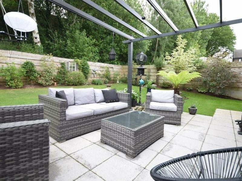 A close-up of the delightfully-styled patio with seating area under a charming pergola.