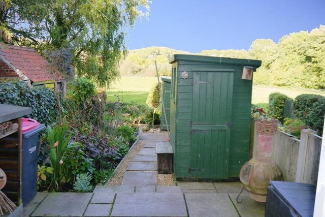 The back garden includes a wooden shed, with power and light connected, as well as a brick-built store.