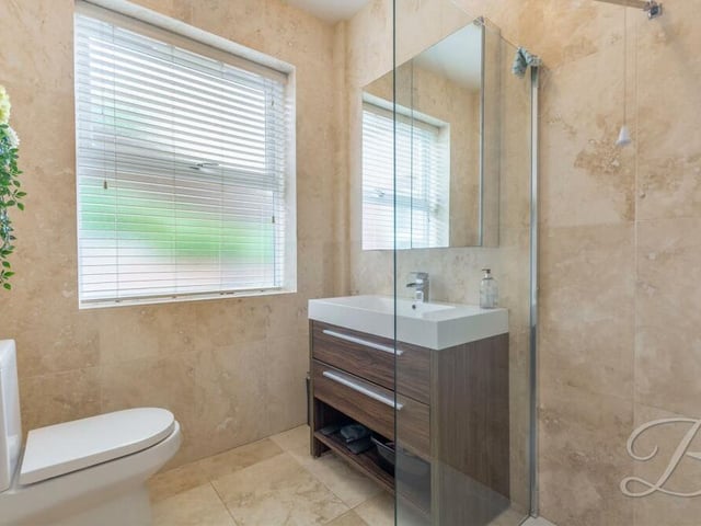 Completing the ground-floor accommodation is this stylish shower room. It's a modern three-piece suite comprising walk-in shower cubicle, low-flush WC and vanity hand wash basin. There's also a chrome, heated towel-rail and tiling to the floor and walls.