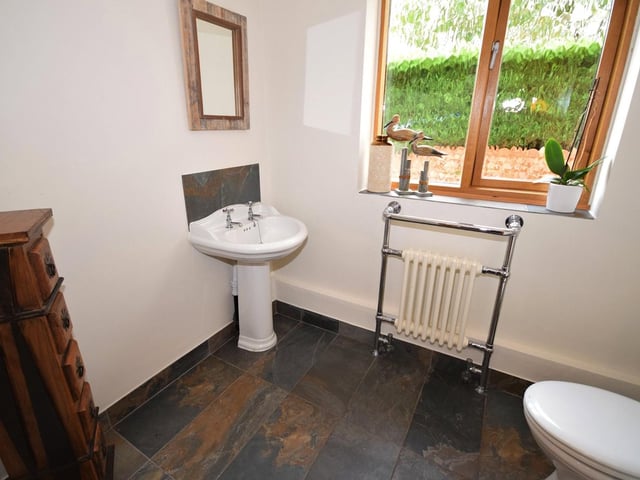 The last of the downstairs rooms to look at is this cloakroom. A newly-fitted suite consists of a high-flush WC., wash basin, chrome heated towel-rail and tiled flooring.