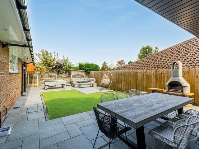 The rear garden has been thoughtfully landscaped to include an artificial lawn and patio areas.
