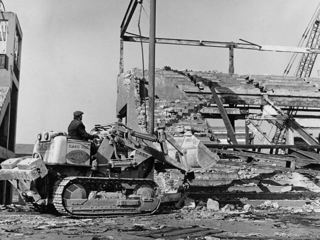A man is pictured operating a bulldozer during the demolition of the Hurst Park grandstand at Field Mill on March 7th 1963.