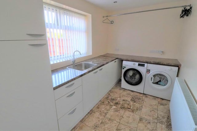 The utility room is large enough for any family. It boasts built-in, modern units, a sink and drainer, plus space and plumbing for a washing machine and tumble dryer. The floor is tiled.