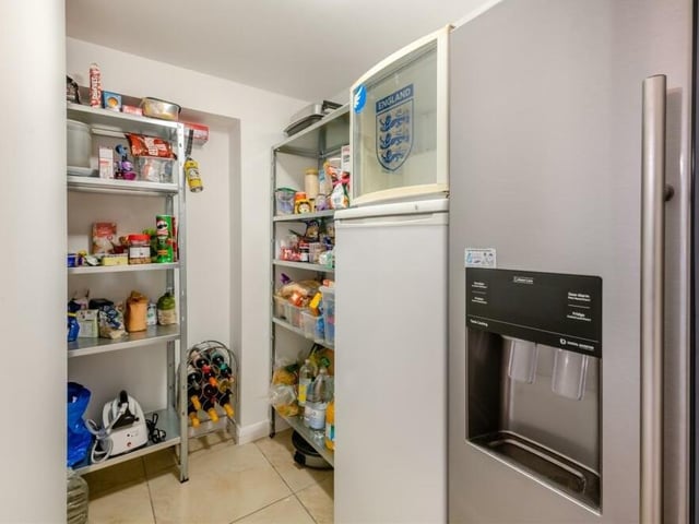 By the kitchen at the £395,000 house is this handy walk-in pantry. It has a tiled floor and ample room for appliances such as a fridge and freezer.