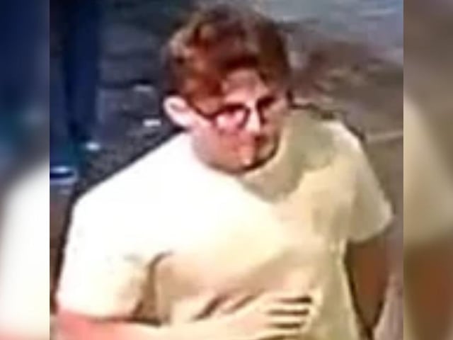 Man, white shirt, grey jeans and glasses on face.