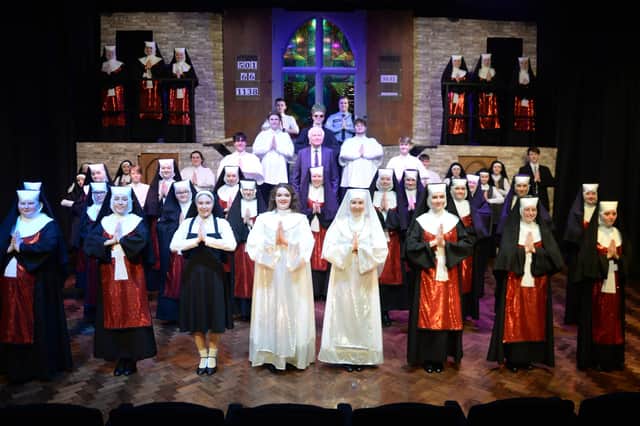 Head teacher John Maher on stage with the cast of a spectacular production of 'Sister Act' by Ashfield School.