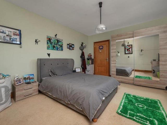 Another impressive bedroom at the Mansfield property. Two windows overlook the front of the house.