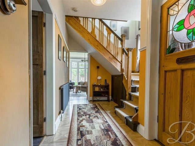 As we prepare to head up to the first floor, let's pass through the inviting entrance hallway to climb the staircase.