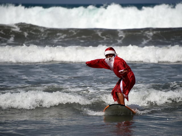 Another reader said Bali was their dream destination for Christmas. Photo: A surfer dressed in a Santa Claus outfit surfs on Kuta beach on Indonesia's resort island of Bali on December 19, 2016. (SONNY TUMBELAKA/AFP via Getty Images)