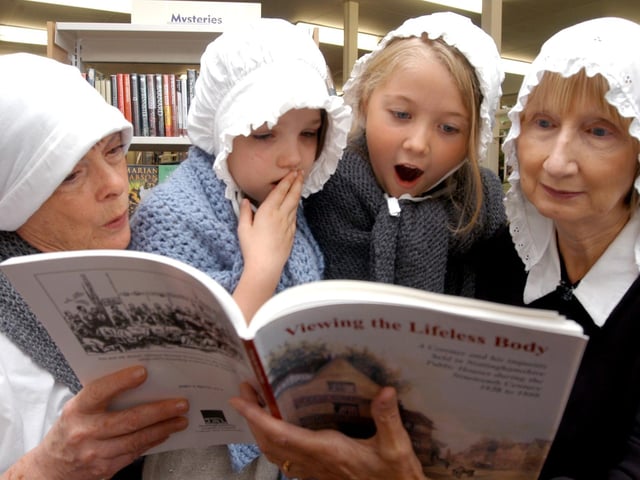 Youngsters Rachael Dubourg and Imogen Whitworth, both aged seven at the time, listen to stories about the workhouse children from Sandra Everitt (left) and Ann Hurt both volunteers from the Southwell Workhouse. The event was held at Forest Town library in 2007.