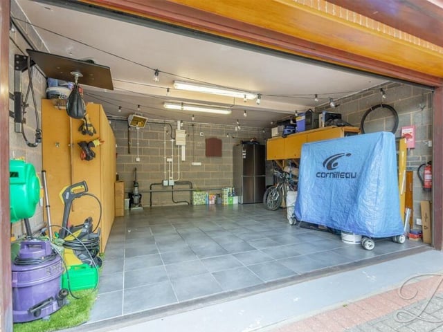 Behind the doors of the garage reveals a clean and multi-functional space that could be used for storage or as a workshop. There are also storage sheds within the rear garden.