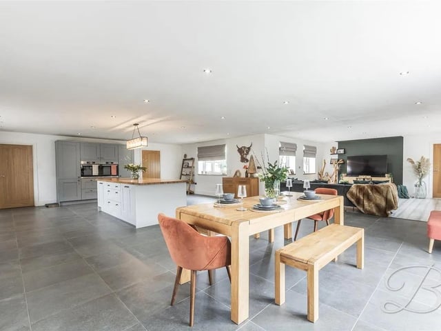 At the heart of the home is a stunning open-plan kitchen, dining, and living space, perfectly designed for modern family life and entertaining.