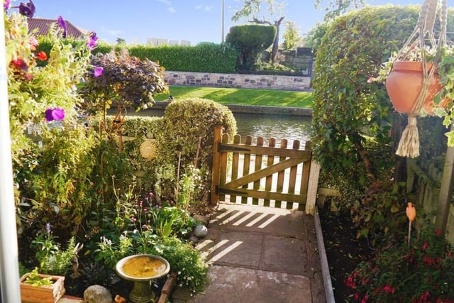 There can't be many prettier sights from a front door than this. A garden containing a variety of plants, flowers and shrub borders and only a wooden gate separating the cottage from the side of a picturesque canal.