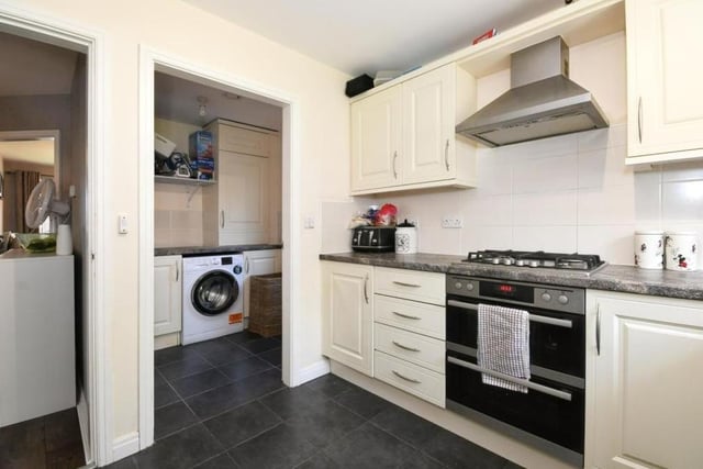 Here is a second view of the kitchen which, like the rest of the four-bedroom house, is in good condition. You can also see the utility room next door.