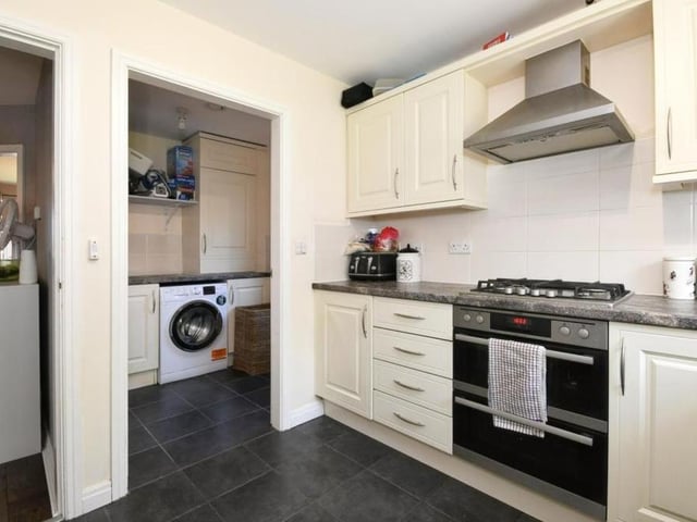 Here is a second view of the kitchen which, like the rest of the four-bedroom house, is in good condition. You can also see the utility room next door.