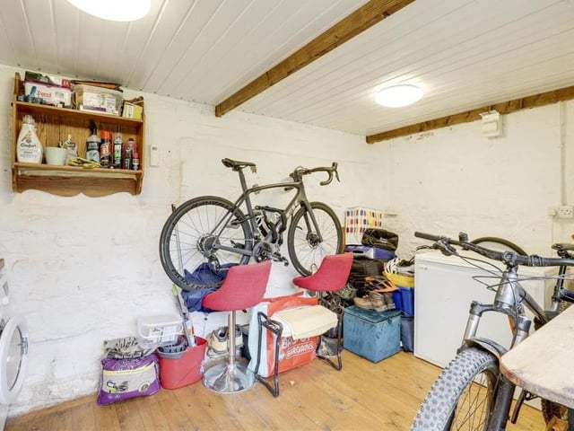 This versatile outhouse is currently being used as a utility room, with space and plumbing for a washing machine and space for a tumble dryer. It also has a base unit with a Belfast-style sink, a wood-effect worktop, power points, wooden flooring and exposed beams to the ceiling.