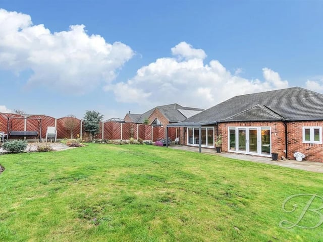 The well-maintained rear garden is a true highlight, featuring a beautifully laid lawn, a charming pergola, and a patio area that is perfect for alfresco dining or simply enjoying the sunshine.