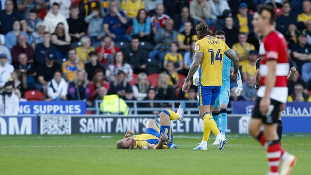 Alfie Kilgour lies injured during the Sky Bet League 2 match against Doncaster Rovers FC at the Eco-Power Stadium
Photo Chris & Jeanette Holloway / The Bigger Picture.media