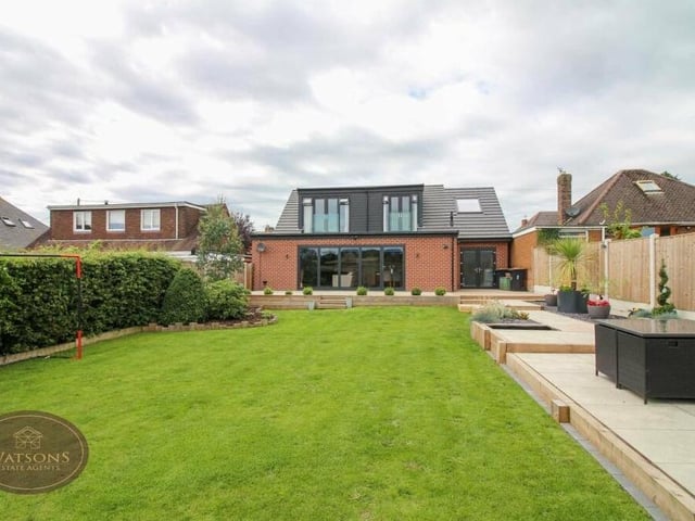 The view from the back of the Newthorpe property is almost as impressive as the front. Looking down the lengthy lawn of the rear garden, you can see the two bedroom balconies and also the huge bi-folding doors that open out from the main living area.