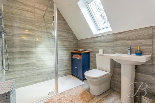 The en suite to the second bedroom, with its walk-in shower, low-flush WC and wash hand basin.