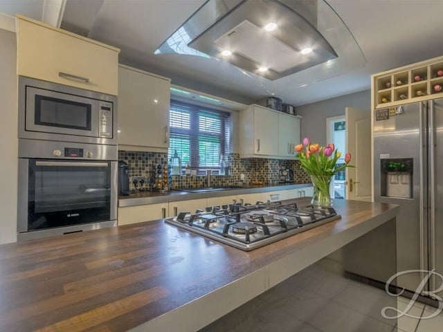 The sparkling kitchen is equipped with a range of matching cabinets and units, with complementary work surfaces and inset sink, as well as a host of appliances.