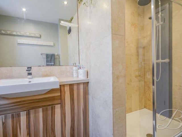The first floor also houses this shower room, which is fitted with an enclosed shower and wash hand basin.