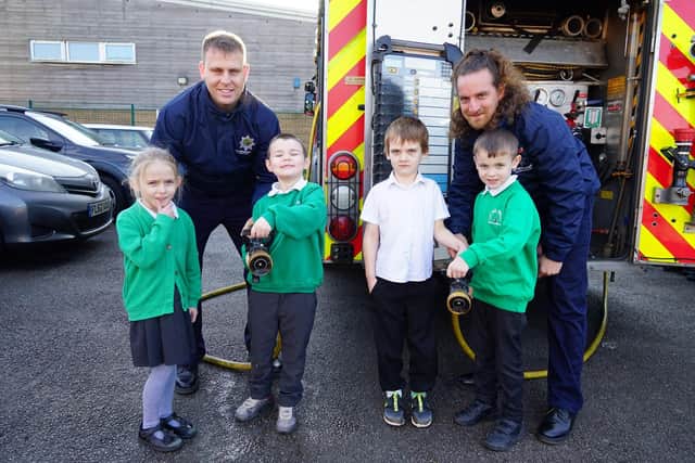 Arran Newcombe and Mat Austin from Warsop fire station show pupils from Oak Tree Primary School and Nursery around the fire engine.