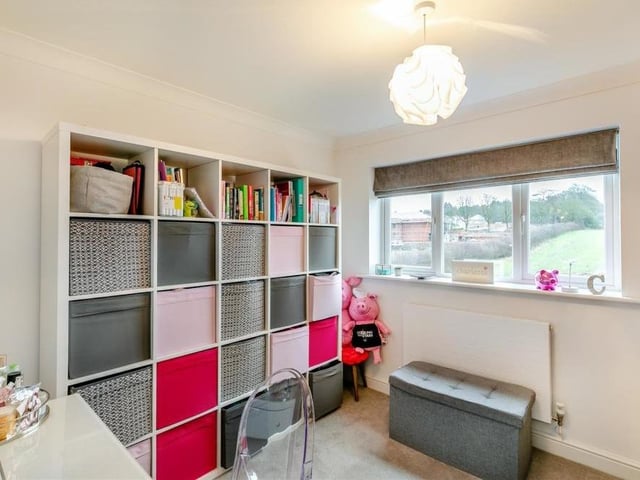 The fifth and final bedroom, which also overlooks the back garden, is a versatile space that could be used for storage. It is sizeable enough, though, to boast two sets of fitted wardrobes with hanging rails and shelves.