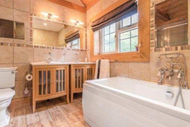 The family bathroom is spacious, boasts a large window to allow for rich natural light and is luxuriously styled throughout.