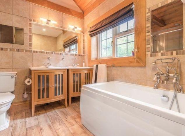 The family bathroom is spacious, boasts a large window to allow for rich natural light and is luxuriously styled throughout.