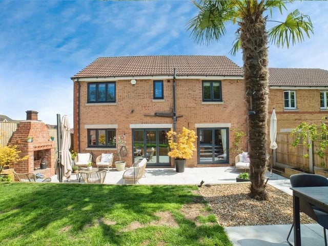 The property has a charming patio area for entertaining and a lush lawned area.