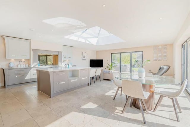 The dining/living kitchen boast underfloor heating, a limestone-tiled floor, ample ceiling spotlights and also a centre-ceiling lantern that floods the room with light. Two sets of bi-fold doors lead out to the south-facing rear garden.