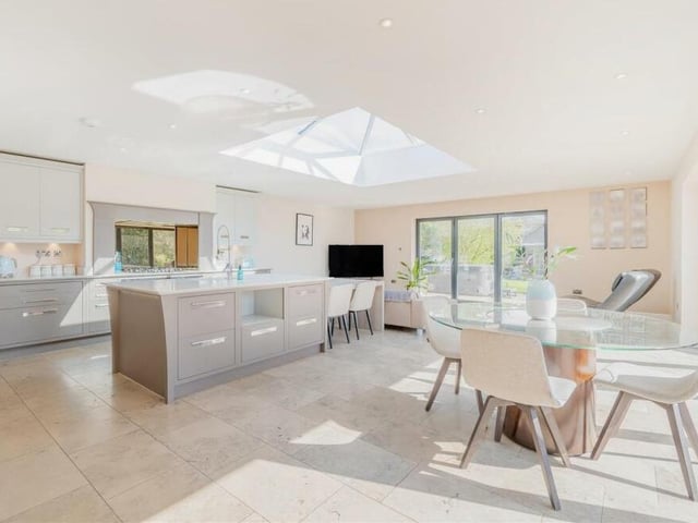 The dining/living kitchen boast underfloor heating, a limestone-tiled floor, ample ceiling spotlights and also a centre-ceiling lantern that floods the room with light. Two sets of bi-fold doors lead out to the south-facing rear garden.