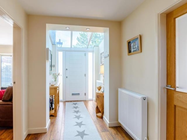 The entrance hallway is very welcoming, and also very bright thanks to a tinted-glass roof to the front portion, allowing an abundance of light to flood in. There is a built-in cloaks cupboard, a laminate floor and six ceiling spotlights.