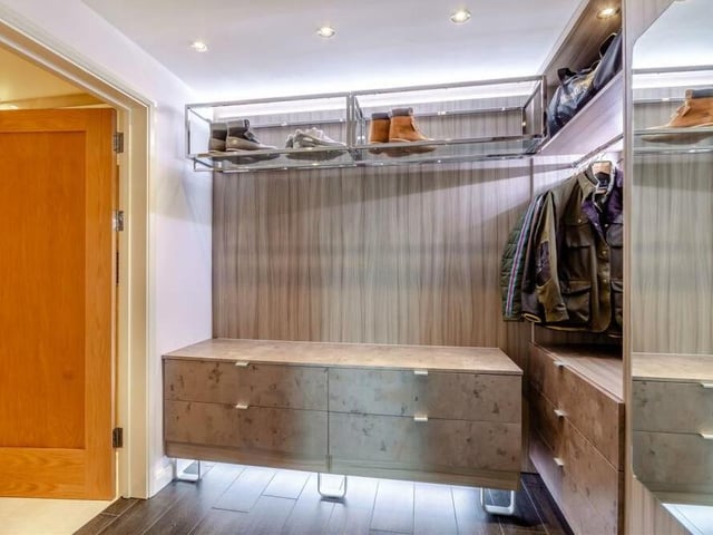 Like the master, the second bedroom is also blessed with a dressing area and en suite facilities. The dressing area comprises fitted wardrobes with hanging rails and shelving, LED lighting and storage space that has an open-rack effect.