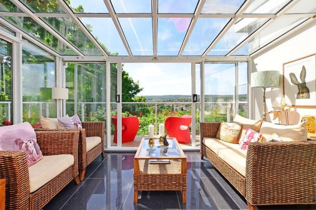 The conservatory leads onto a wraparound balcony with decking, glass, and beautiful views.