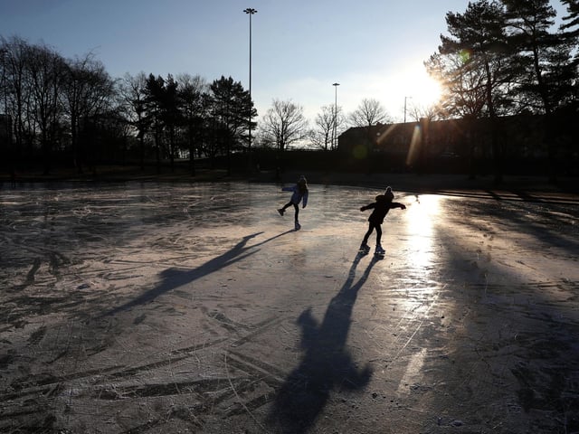 People skate on a frozen pond at Victoria Park in Glasgow.