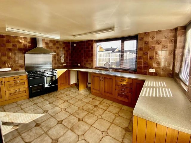 The open-plan kitchen is the largest room in the bungalow when combined with its dining area and extra living space. It features a range cooker with chrome splashback and hood extractor fan over, and there is space for further appliances, as well as plumbing for a washing machine.
