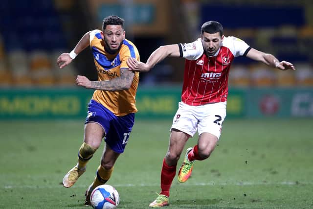 Kellan Gordon of Mansfield Town is pulled back by Liam Sercombe of Cheltenham Town.