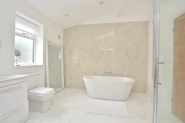 This Jack and Jill en-suite bathroom includes a free standing bath, shower, wash hand basin, W.C and attractive marble effect tiling.