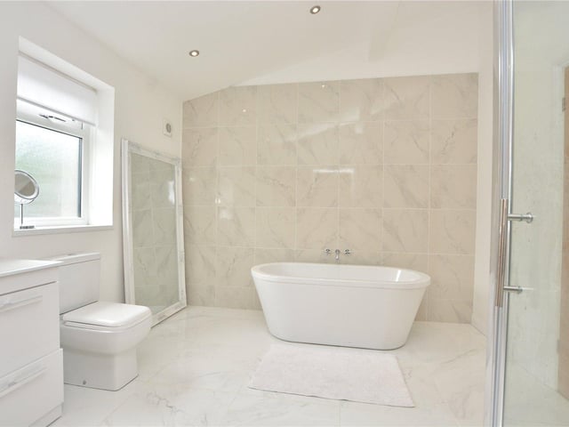 This Jack and Jill en-suite bathroom includes a free standing bath, shower, wash hand basin, W.C and attractive marble effect tiling.