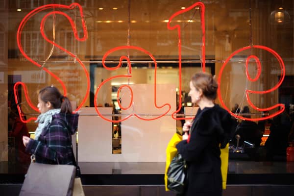 Pedestrians pass a store advertising sales discounts. Picture: Frantzesco Kangaris/Bloomberg via Getty Images.