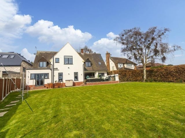 This view from the rear of the property shows the extensive, well-maintained lawn.