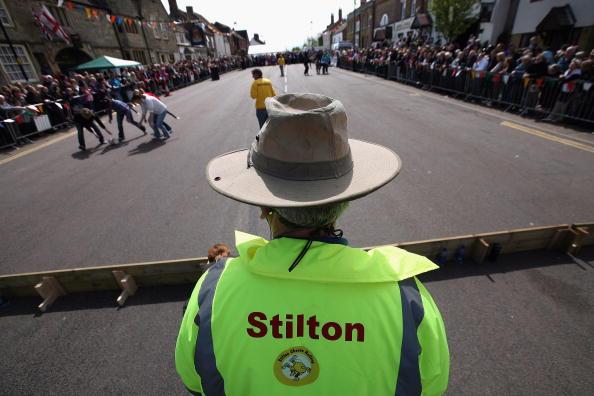 An official watches as competitors participate in the Stilton Cheese rolling competition on Stilton High Street. Incredibly, since the 1920s, it has been illegal to produce Stilton anywhere outside Derbyshire, Nottinghamshire and Leicestershire.