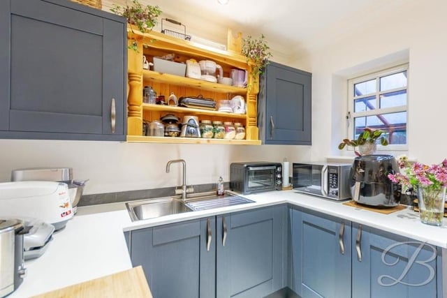 Not far from the kitchen is this matching utility room, with more shaker-style units and cabinets, an inset stainless steel sink and integrated freezer and washing machine. There's ample space for other appliances too.
