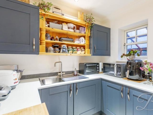 Not far from the kitchen is this matching utility room, with more shaker-style units and cabinets, an inset stainless steel sink and integrated freezer and washing machine. There's ample space for other appliances too.