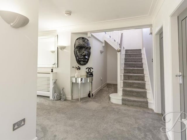 It's time to shoot upstairs now, via the entrance hall, which has a carpeted floor and attractive wall lights.
